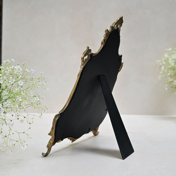 Baroque-style ornate tabletop mirror with an antique gold frame and sculpted detailing.
