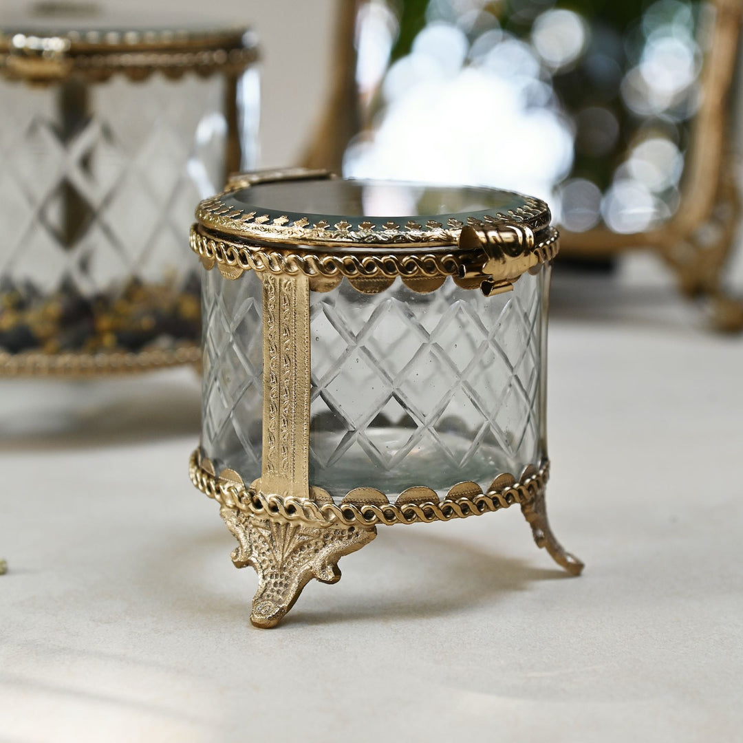 brass and glass jewellery box with a hinged lid and intricate detailing.