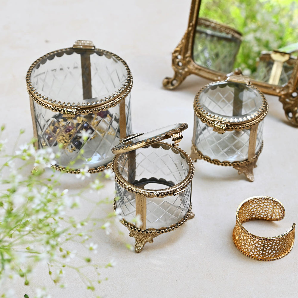 brass and glass jewellery box with a hinged lid and intricate detailing.