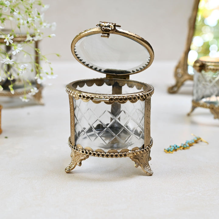 brass and glass jewellery box with a hinged lid and intricate detailing.