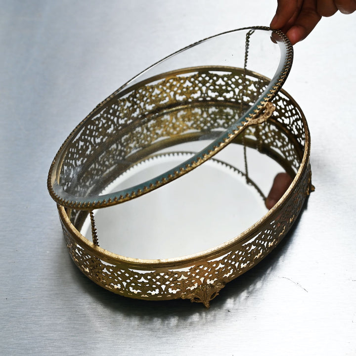 Large brass oval box with glass lid and  intricate brass detailing.