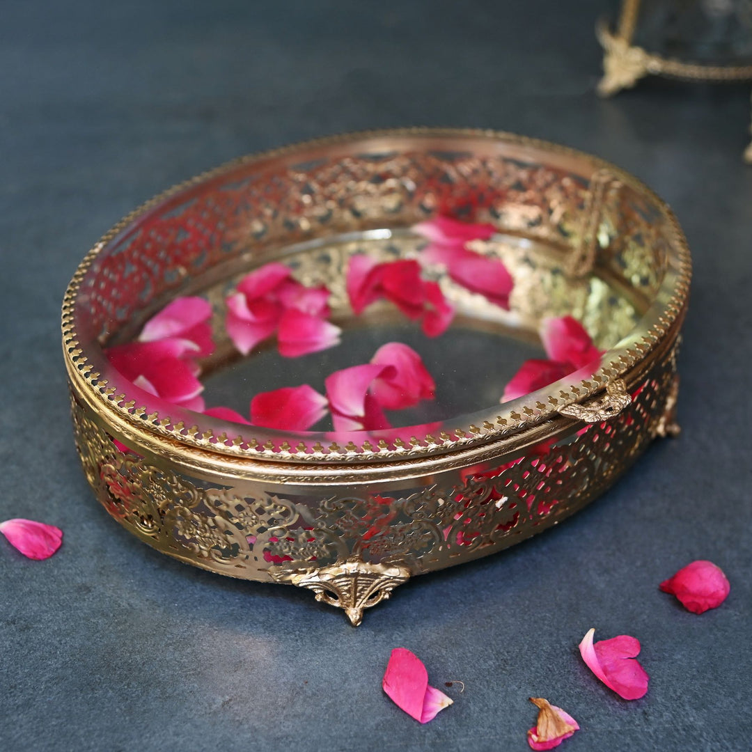 Large brass oval box with glass lid and  intricate brass detailing.