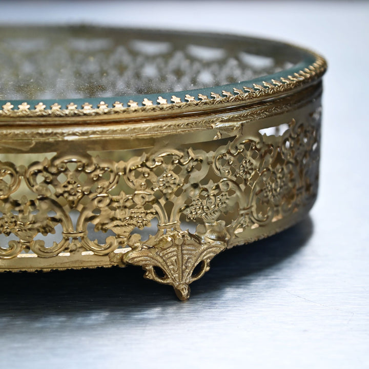 Large brass oval box with glass lid and  intricate brass detailing.