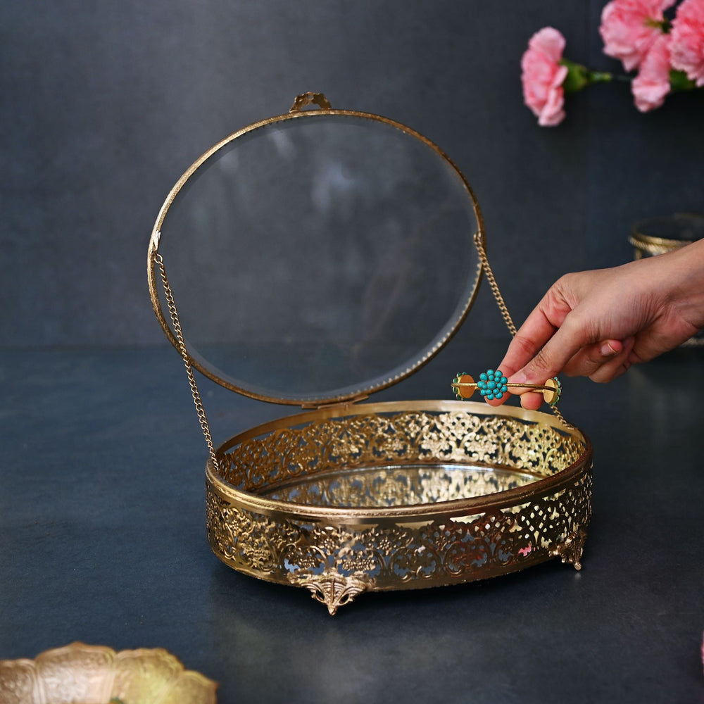 Large brass oval box with glass lid and  intricate brass detailing.