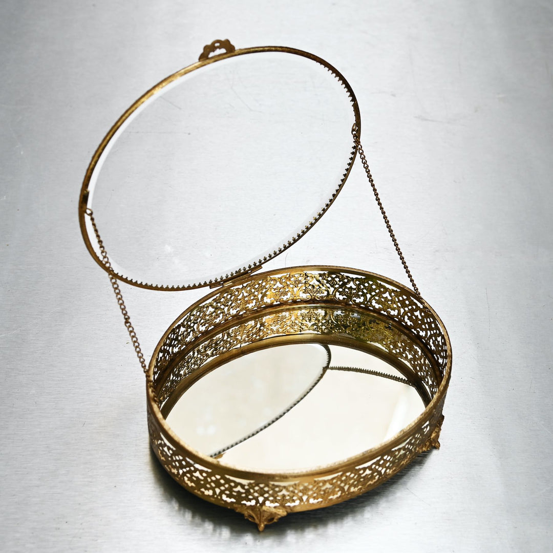 Large brass oval box with glass lid and  intricate brass detailing.