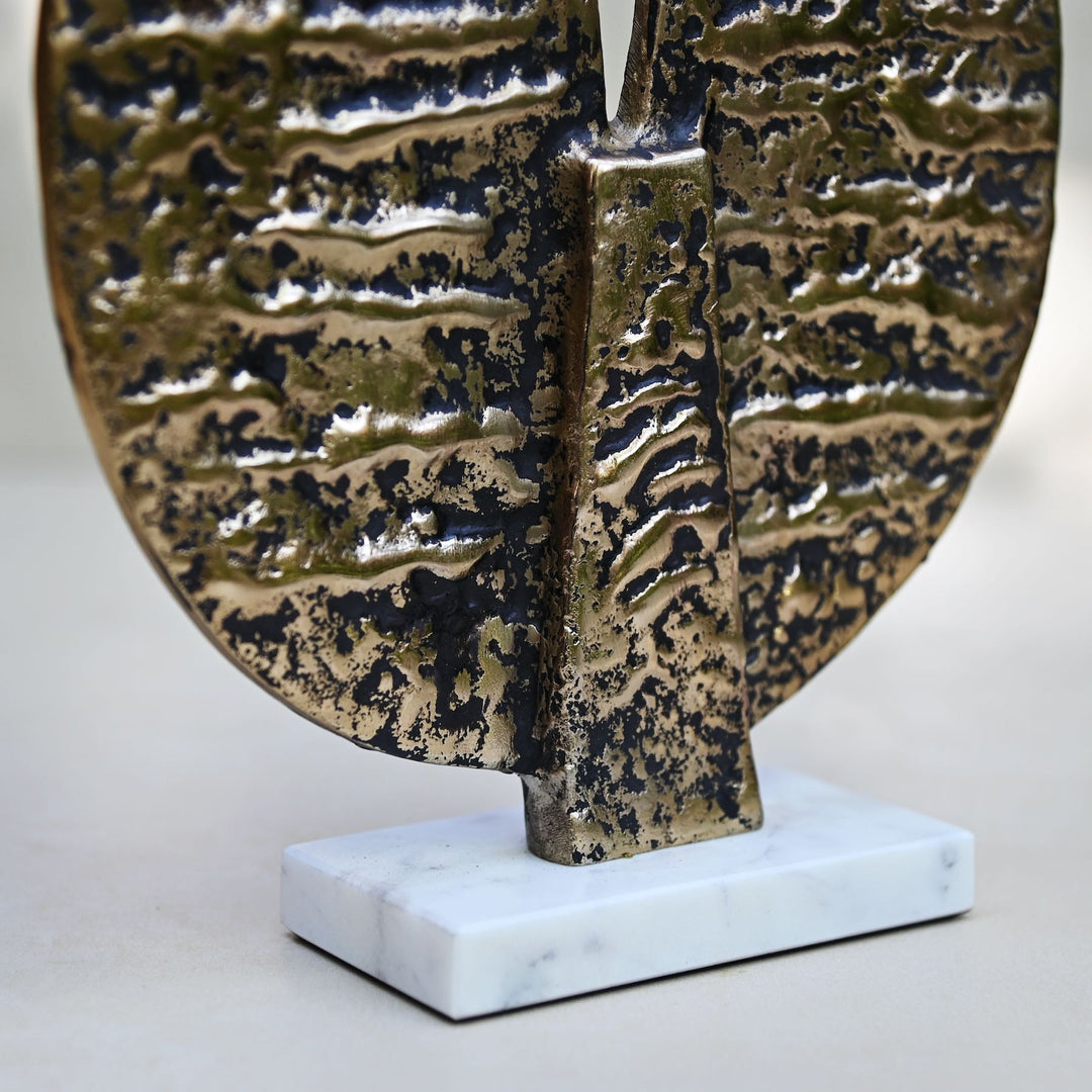 Round antique gold table décor on a marble stand