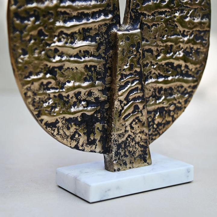 Round antique gold table décor on a marble stand