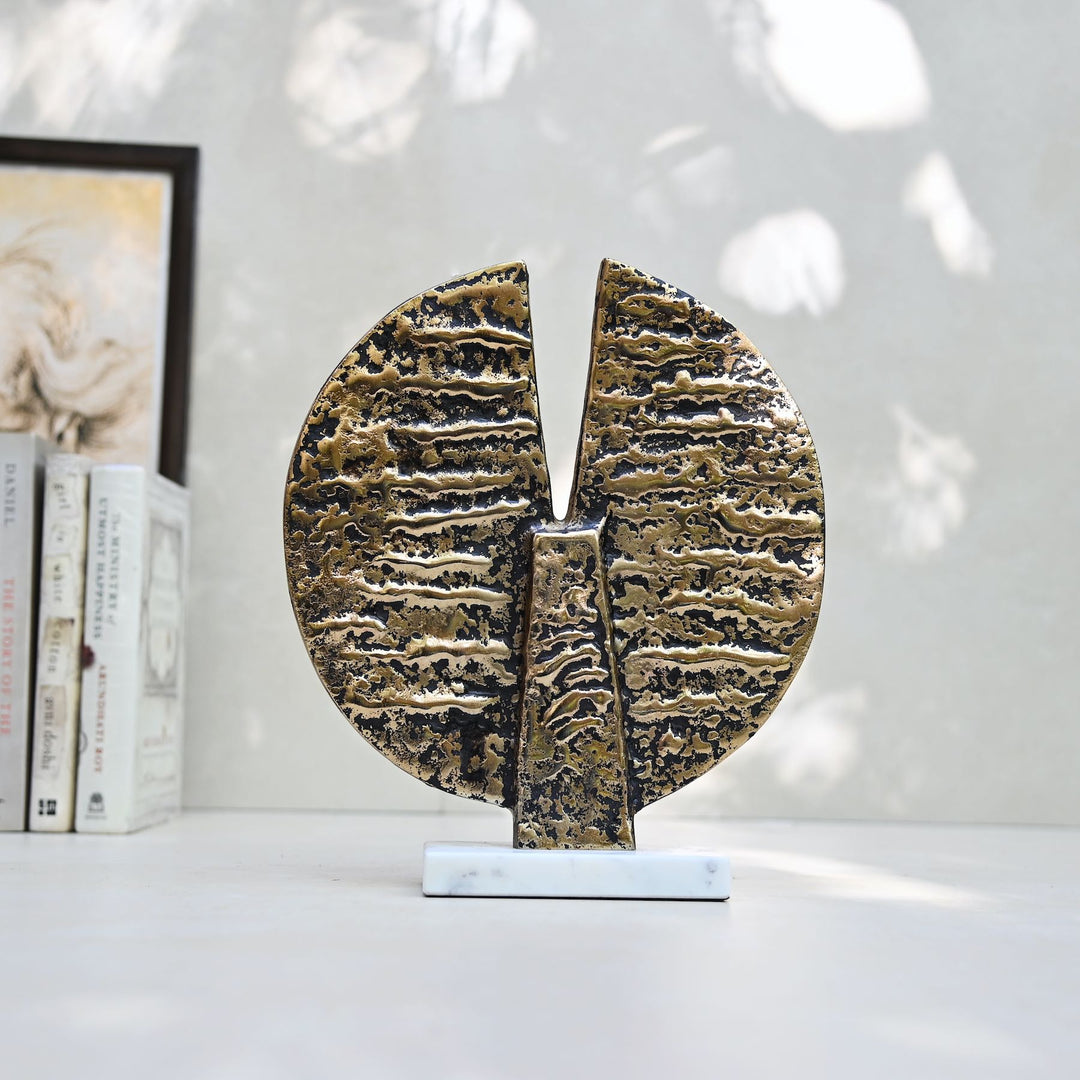 Round antique gold table décor on a marble stand
