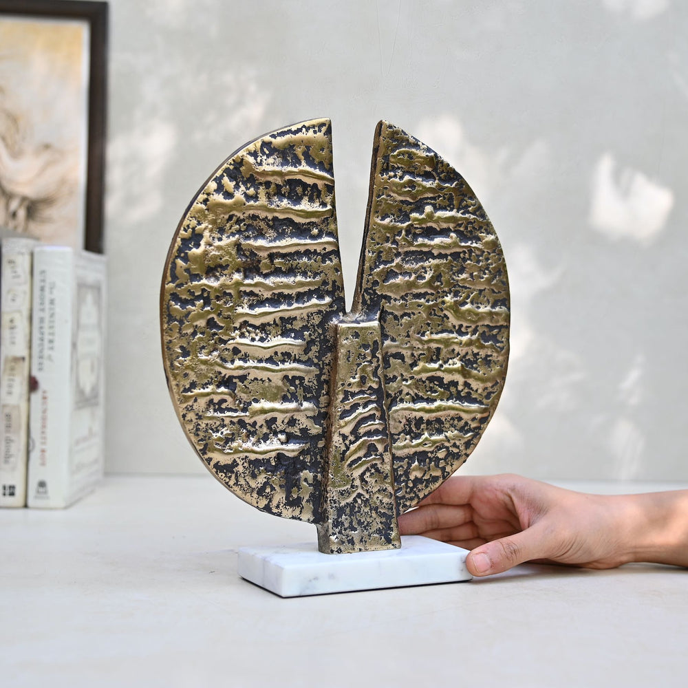 Round antique gold table décor on a marble stand