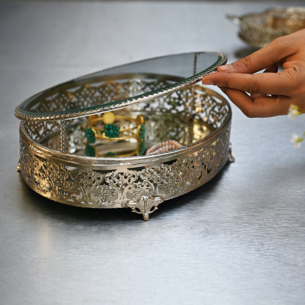 Large silver-finish glass oval box with brass edges and intricate detailing.