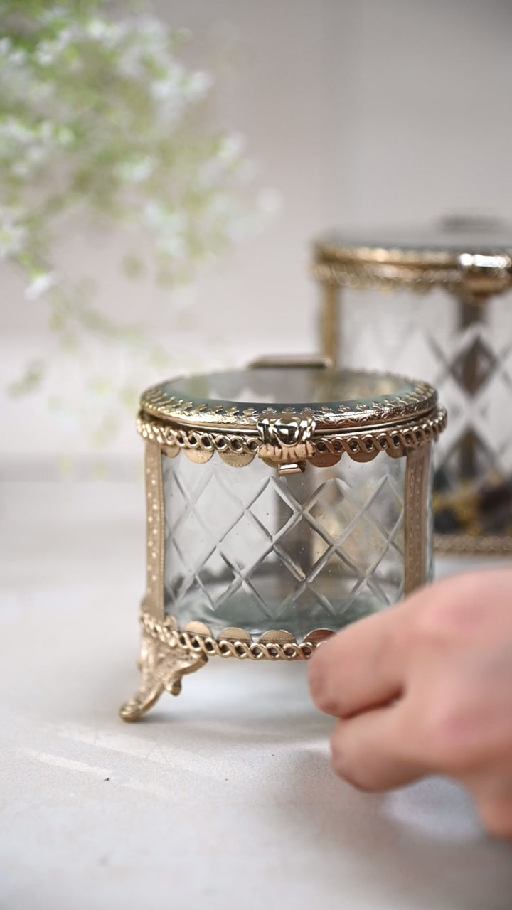 brass and glass jewellery box with a hinged lid and intricate detailing.