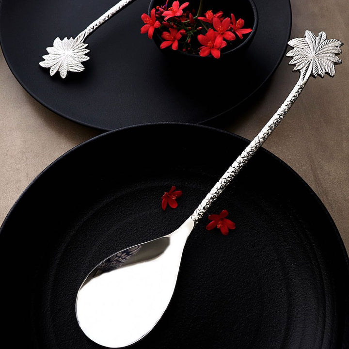 steel serving spoon with palm-leaf shaped handles
