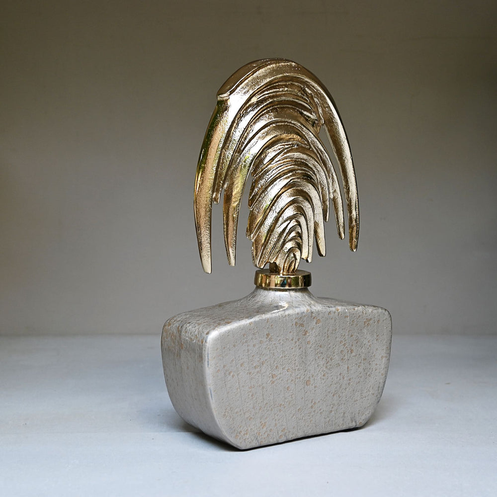 Angled view of a silvered glass decorative jar with a sweeping golden stopper