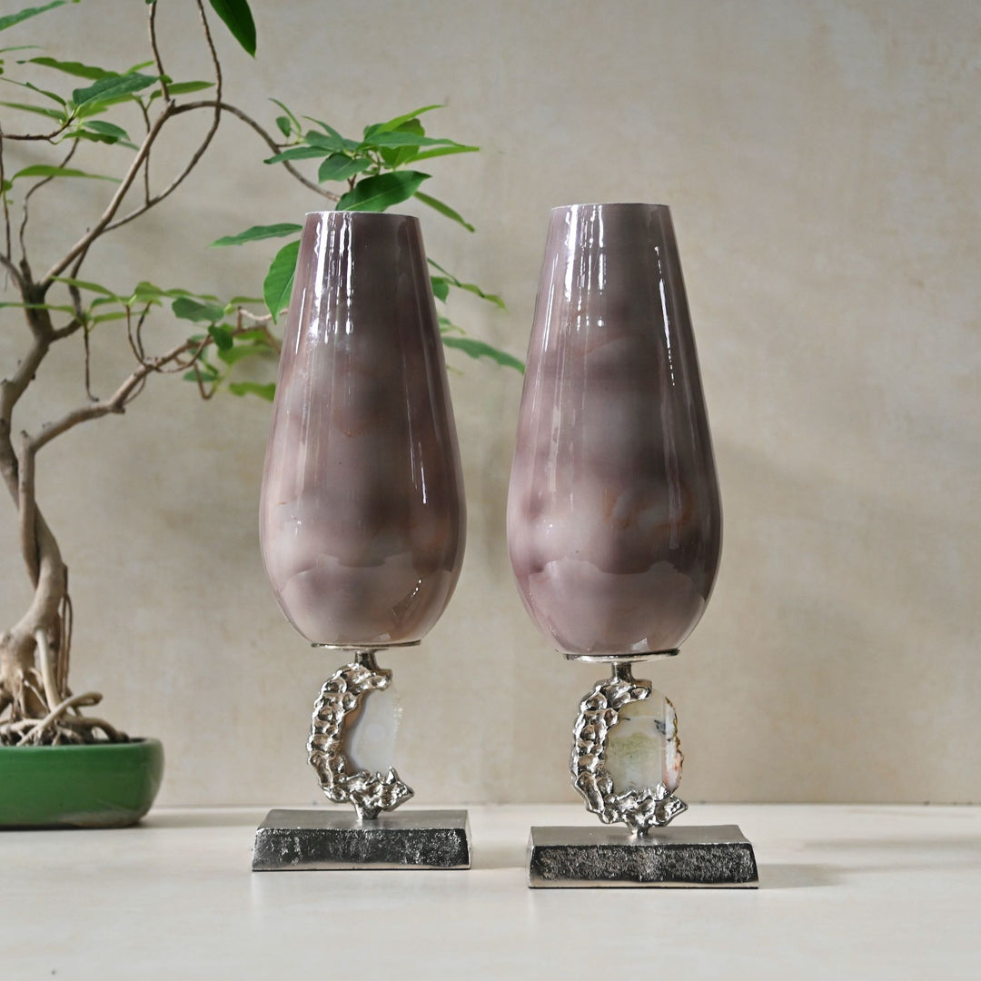 Two decorative vases with marble-like texture on metallic stands against a neutral background.
