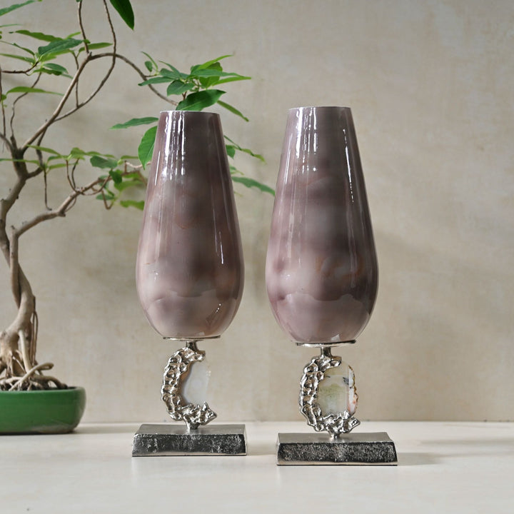Two decorative vases with marble-like texture on metallic stands against a neutral background.