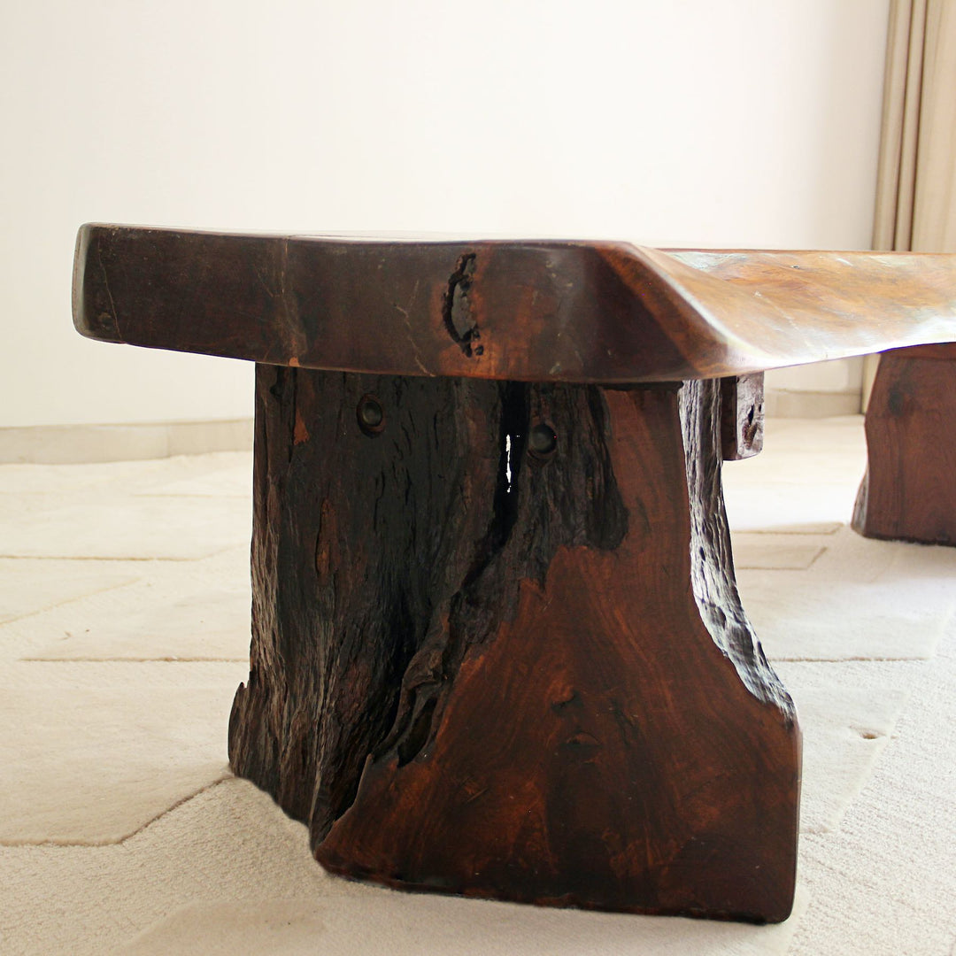 Wooden table with a natural, rustic design on a light-colored floor.