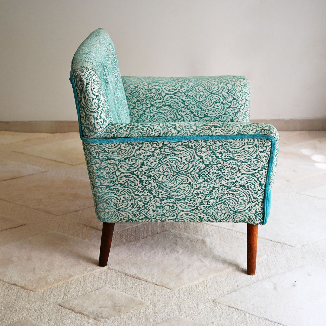 Patterned armchair on a light wooden floor with a neutral wall background