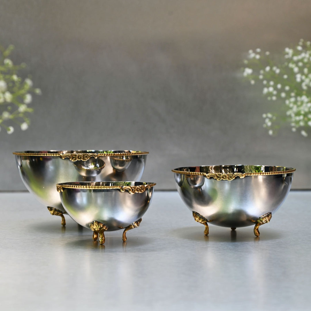 Set of three decorative bowls with gold accents on a neutral background