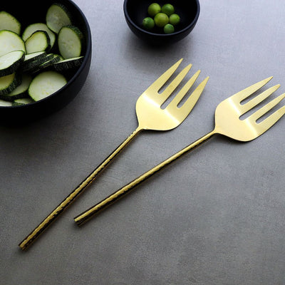 gold-coloured serving forks