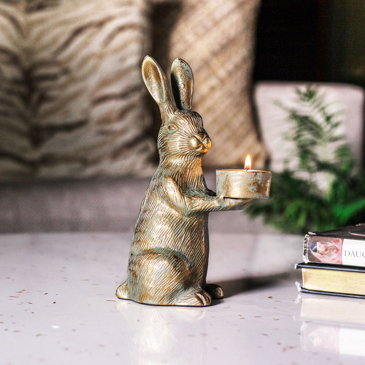 Side view of the rabbit holding its tealight cup in its paws