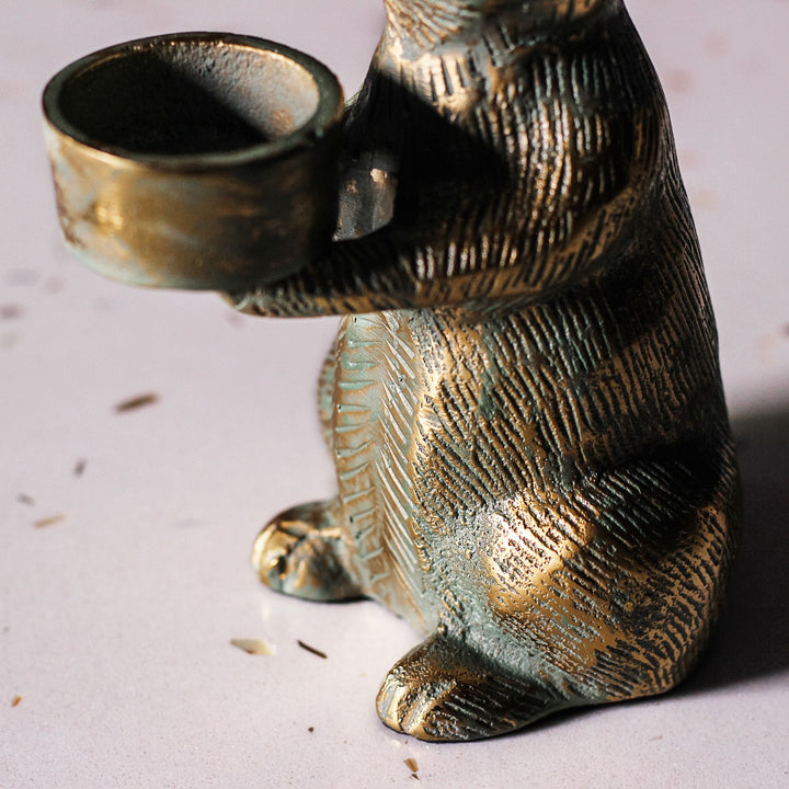 Detail of the rabbit’s empty tealight cup, textured fur and paws