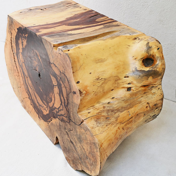 A sliced and carved teak flat console table displayed with decorative items on top.