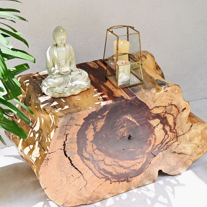 A sliced and carved teak flat console table displayed with decorative items on top.