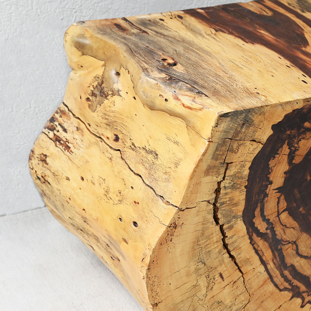 A sliced and carved teak flat console table displayed with decorative items on top.